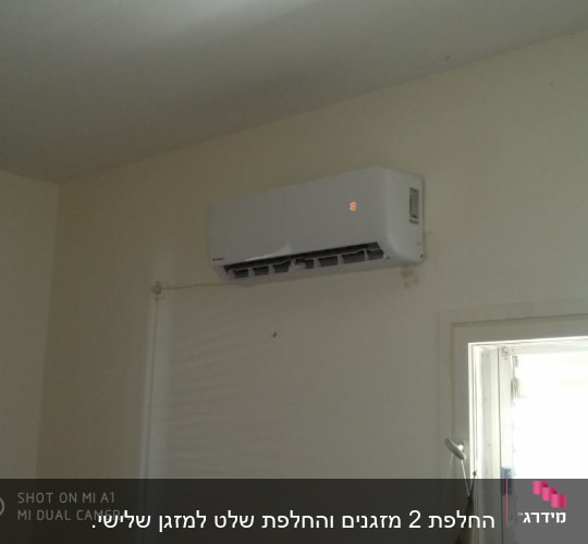 מזגן מותקן על קיר עם תצוגה דולקת